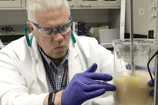 Dr. Andy Clark mixes a beaker of Lavengel in his university laboratory